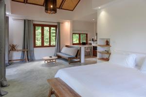 1 dormitorio con 1 cama, 1 silla y 1 mesa en Boonya Swiss Home en Chaloklum