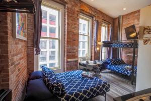 a room with a bed and a desk and two windows at Empire Broadway Retreats in New York