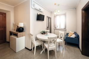 - un petit salon avec une table et des chaises blanches dans l'établissement Casa Alice Lucca centro, à Lucques
