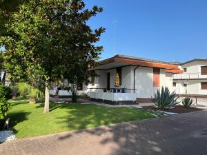 a house with a lawn in front of it at BUNGALOW CAVALLINO LIDO in Cavallino-Treporti