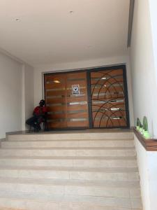 um quarto com uma grande porta de madeira e escadas em CHEZ CODOU FANN - POINT E em Dakar