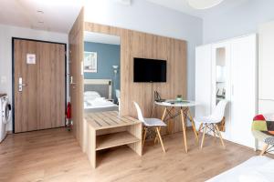 a room with a bed and a table and chairs at RentPlanet - Apartamenty Wolska in Warsaw