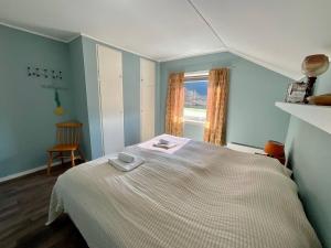 1 dormitorio con 1 cama blanca y ventana en Flakstad Beach Panorama Lofoten, en Ramberg
