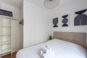 a bedroom with a bed and a clock on the wall at Cosy Vendôme - A 5min du Parc de la Tête dOr in Lyon