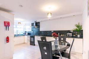 a kitchen with a glass table and chairs at Bodmin House - Charming 3-Bedroom Terrace House with Private Enclosed Garden in Wallsend