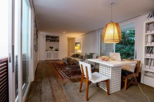 a living room with a table with a laptop on it at Tropical Contemporary Suites in Paraty