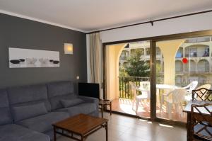 uma sala de estar com um sofá e uma mesa em Jardins del Mar 48 em L'Estartit