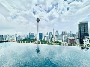 een overloopzwembad met uitzicht op de stad bij Ceylonz Suites KL City by One39KL in Kuala Lumpur