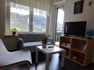 a living room with a tv and a couch and a table at Bukor Apartments in Lukovica pri Domžalah