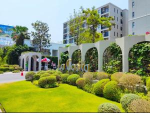 un jardin en face d'un bâtiment avec un panneau dans l'établissement HuaHin La Casita condo Quiet, cozy room Netflix#1, à Hua Hin