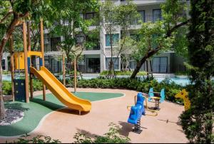 a playground in front of a building with a slide at HuaHin La Casita condo Quiet, cozy room Netflix#1 in Hua Hin