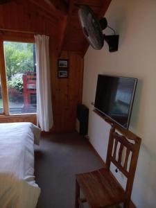 a bedroom with a bed and a flat screen tv at Complejo Paimun in San Martín de los Andes