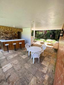 a patio with a table and chairs and a counter at Solar da Montanha in Petrópolis