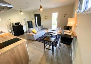 a living room with a table and a couch at Aux Pommiers - Poitiers CHU - CAMPUS - La Conciergerie in Poitiers