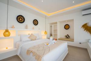 a white bedroom with a bed and a table at Villa Zahka - 1BR Private Luxury Hideaway near Seseh Beach in Canggu