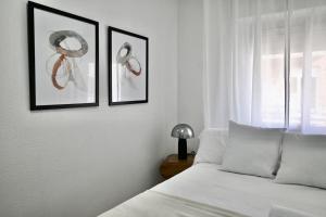 1 dormitorio con 2 cuadros y 1 cama en For You Rentals Coqueto y Cómodo apartamento Madrid, en Madrid