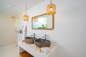 two sinks in a bathroom with a mirror and lights at Villa Zahka - 1BR Private Luxury Hideaway near Seseh Beach in Canggu