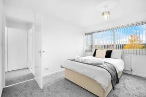 ein weißes Schlafzimmer mit einem großen Bett und einem Fenster in der Unterkunft JLR,NEC,B'Ham Airport,Entire House,WI-FI,Netflix in Birmingham