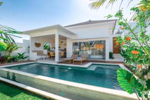 a villa with a swimming pool in front of a house at Villa Zahka - 1BR Private Luxury Hideaway near Seseh Beach in Canggu