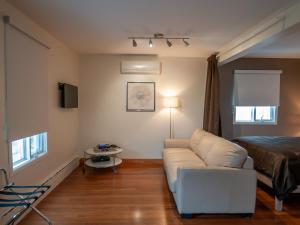 a living room with a couch and a bed at Résidence Touristique Chicoutimi in Saguenay