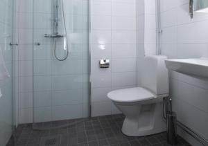 a bathroom with a shower and a toilet and a sink at Hotell Havsporten in Karlholmsbruk