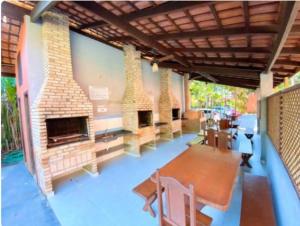 a patio with a brick fireplace and a table and chairs at Lindo Flat em Maresias, 100m da Praia in Maresias