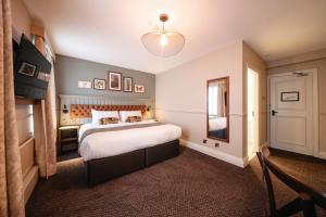 a bedroom with a large bed and a mirror at The Bears Head by Innkeeper's Collection in Sandbach