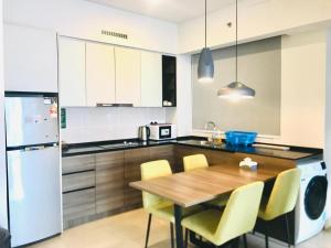 a kitchen with a wooden table and yellow chairs at Genting Premium Suite Windmill Upon Hills by JAz Home Suites in Genting Highlands