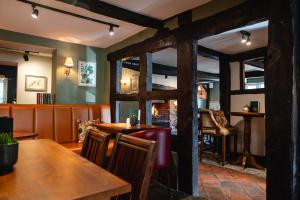 een eetkamer met houten tafels en stoelen bij The Bears Head by Innkeeper's Collection in Sandbach