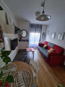 uma sala de estar com um sofá vermelho e uma mesa em Apartamento 4 pax Airport Wanda Ifema WiFi em Madri