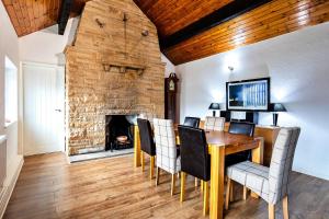 une salle à manger avec une table, des chaises et une cheminée dans l'établissement Finest Retreats - Woodstock Lodge, à Bishop Middleham