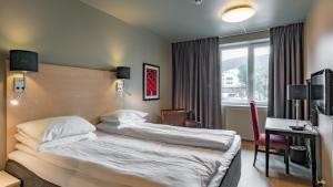 a hotel room with two beds and a desk at Scandic Meyergården in Mo i Rana