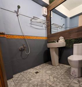 a bathroom with a sink and a toilet and a mirror at Blackport Seaview Homestay in Yanliau