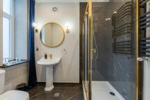 y baño con lavabo y ducha. en KaJo Apartamenty en Świdwin