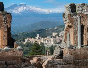 a view of a city with a mountain in the background at San Domenico Palace, Taormina, A Four Seasons Hotel in Taormina