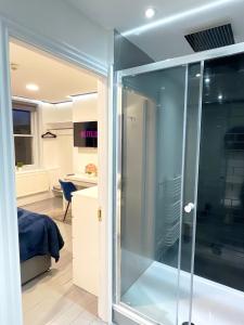 a glass shower in a room with a bedroom at Central penthouse by HNFC Stays in Newcastle upon Tyne