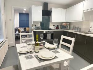 a kitchen with a table with glasses and a bottle of wine at Central penthouse by HNFC Stays in Newcastle upon Tyne