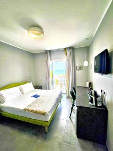 a bedroom with a bed and a desk and a television at A Casa di Alessandra - Rooms in Castellabate