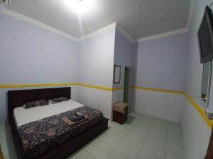 a small bedroom with a bed and a television at Homestay 77 Borobudur in Borobudur