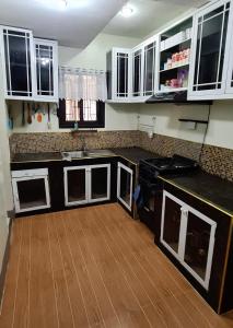 eine Küche mit weißen Schränken und Holzböden in der Unterkunft M & D Rentals by Jick in Butuan