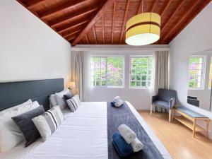 - une chambre avec un grand lit dans l'établissement Casa da Ribeira Cottage, à Ribeira Grande
