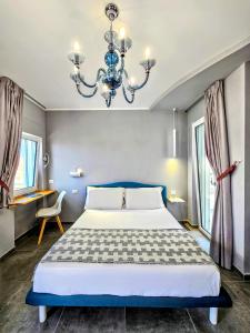 Un dormitorio con una cama grande y una lámpara de araña. en A Casa di Alessandra - Rooms en Castellabate