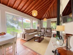 een woonkamer met een bank en een tafel bij Casa da Ribeira Cottage in Ribeira Grande