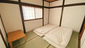 a small room with two beds and a table at 民宿奈良山月 in Nara