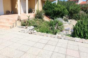 a garden with rocks and plants next to a house at Chambre privée cosy, salle de bain et terrasse in Millas