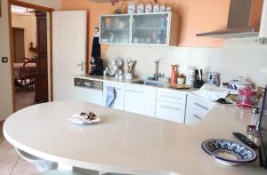 una cocina blanca con una mesa blanca en una habitación en Chambre privée cosy, salle de bain et terrasse, en Millas