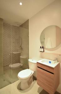 a bathroom with a toilet and a shower and a sink at Cadena Hotelera Rey es in Bogotá