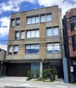 a large brick building with windows on a street at Cadena Hotelera Rey es in Bogotá