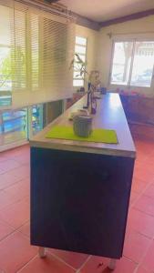 a kitchen with a counter with a green island at Maison de campagne in Kourou