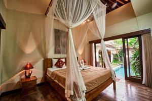 a bedroom with a bed with a canopy at Pondok Buda Merta in Ubud